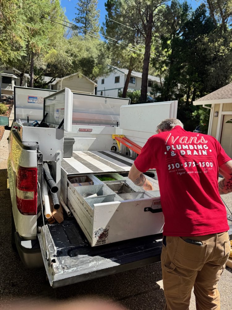 Ivan in his red Ivan's Plumbing & Drain shirt loading the work truck in the foothills