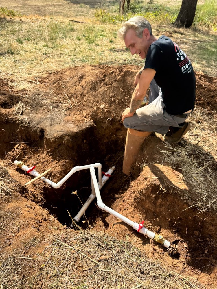 Ivan repairing a buried water line in a trench
